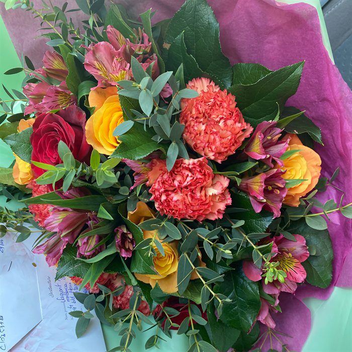 Bouquet tons chauds, œillets corail, roses orange et alstroemères