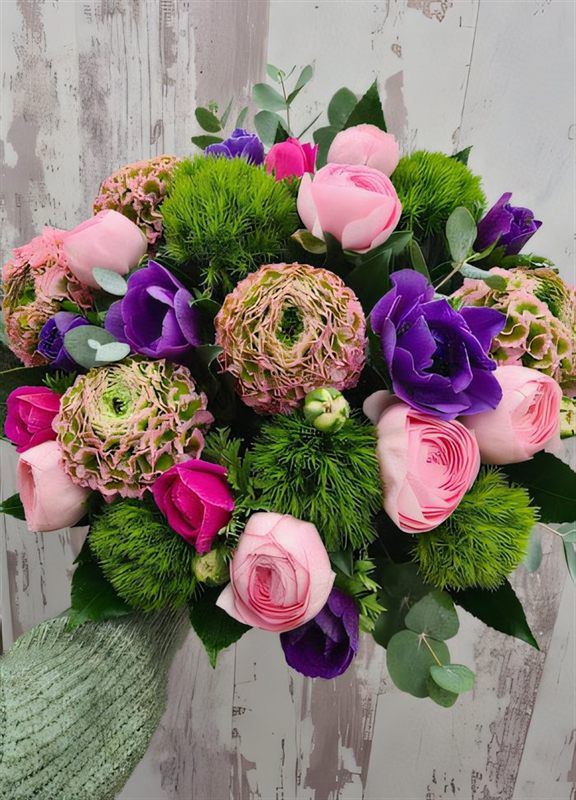 Bouquet de renoncules roses, anémones violettes et œillets verts