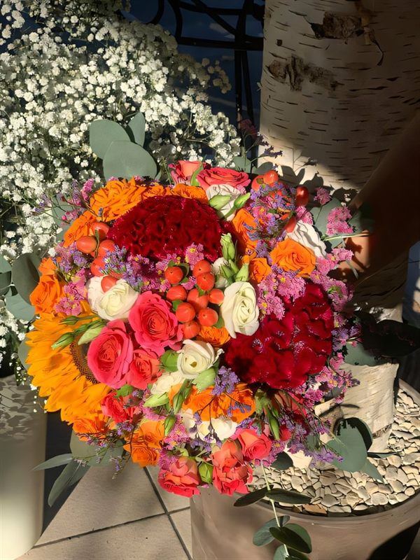 Bouquet vibrant, tournesol, œillets corail, roses colorées et gypsophile