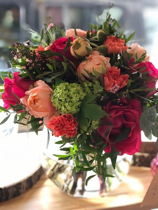 Bouquet en vase transparent, roses pêche, roses fuchsia et viburnum vert