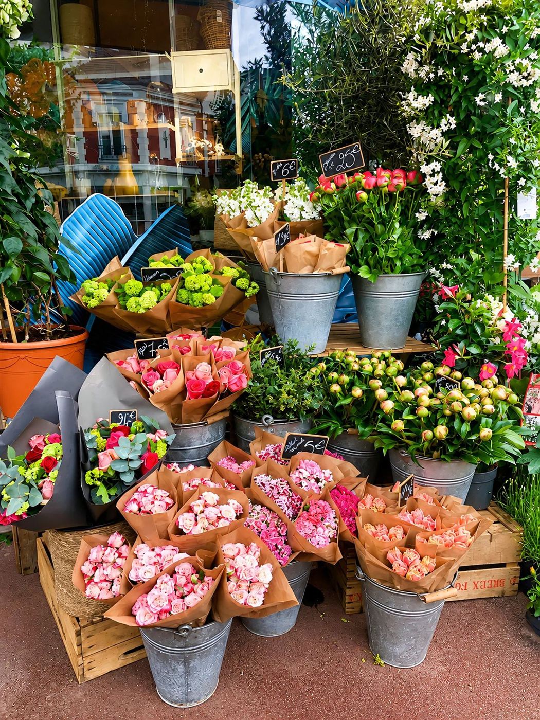 Étalage extérieur — roses pâles, hortensias, tulipes et hypericum en seaux zinc