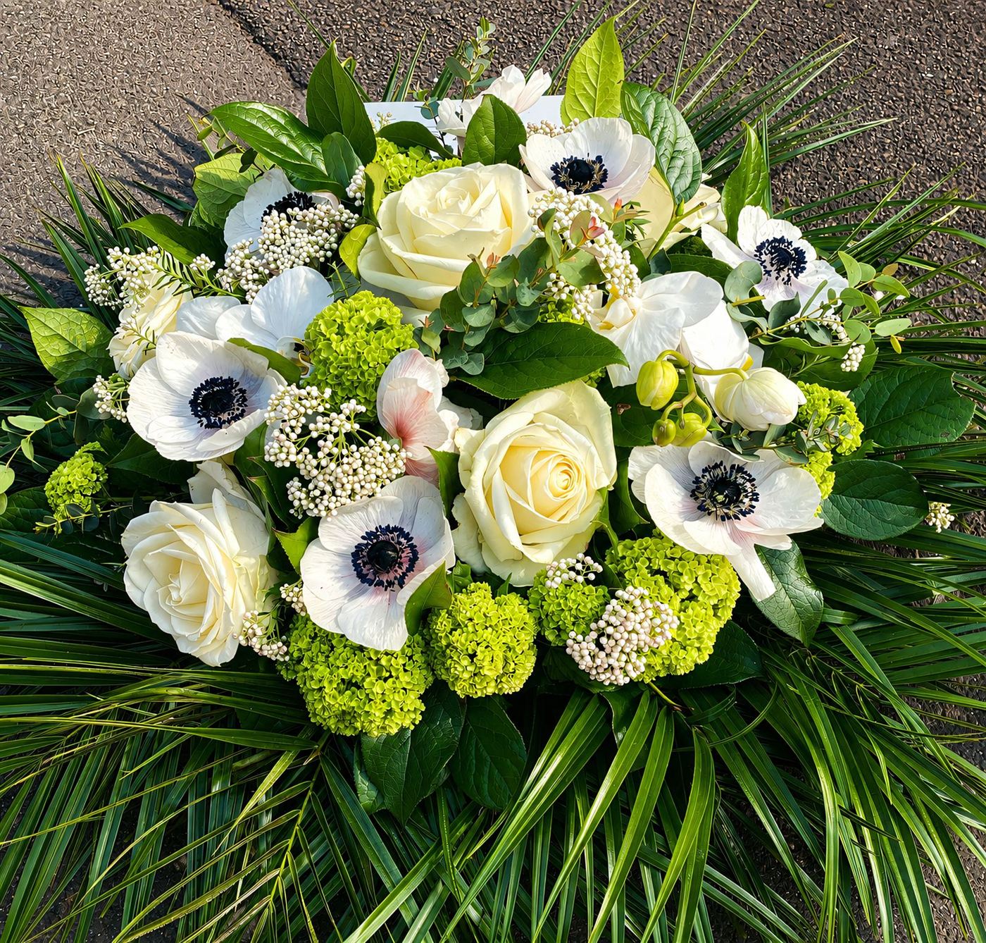 Bouquet rond deuil, fleurs fraîches aux tons doux pour message d'hommage
