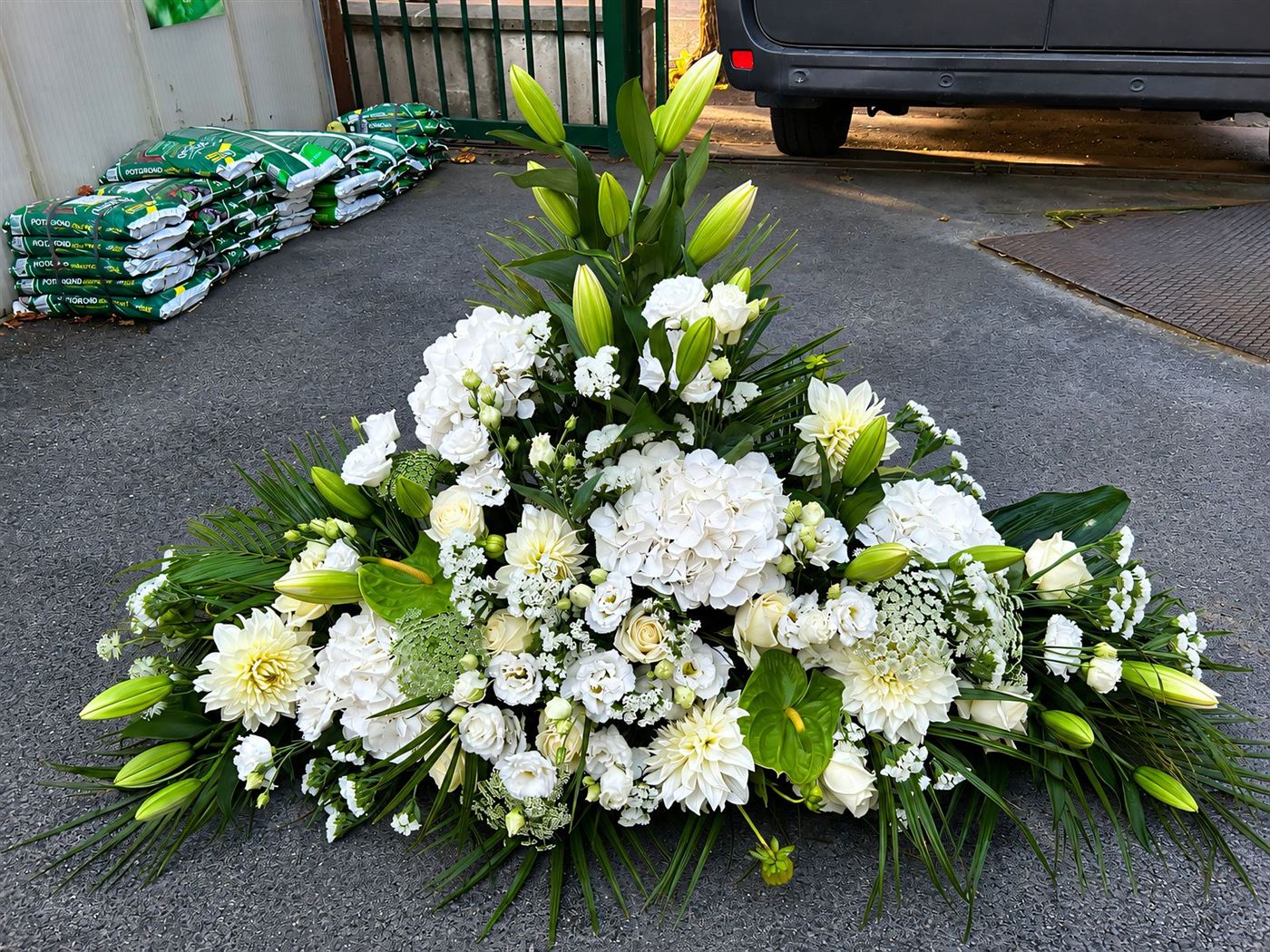 Gerbe haute triangulaire blanche, lys, roses et œillets