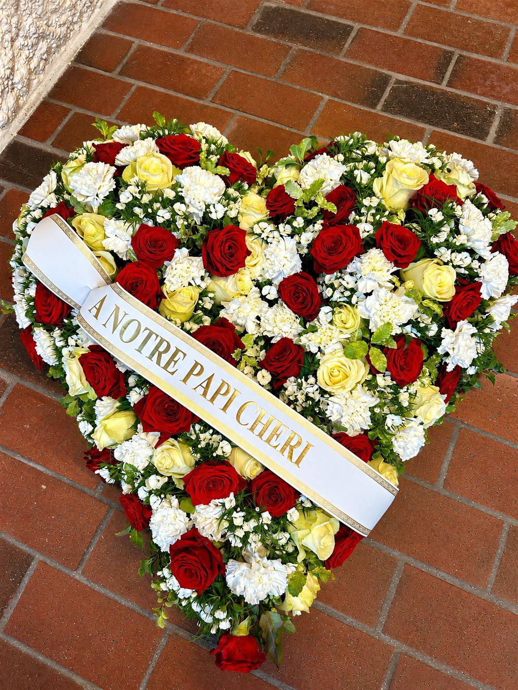 Coussin en cœur bicolore, chrysanthèmes blancs, roses jaunes et roses rouges
