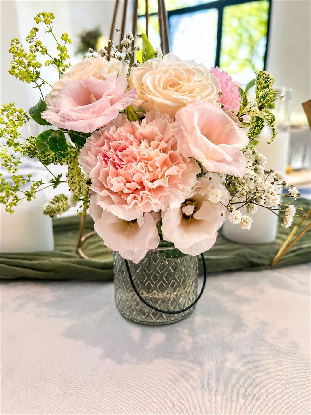Centre de table en vase gravé, roses, œillets pâles, lisianthus et gypsophile