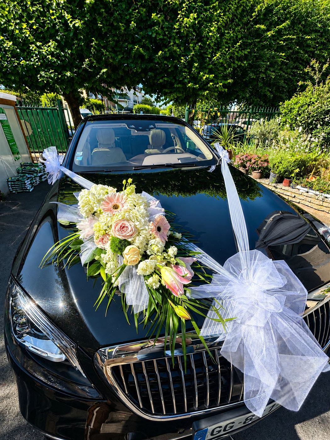 Décoration capot voiture noire, bouquet roses pâles, gerberas et tulle blanc