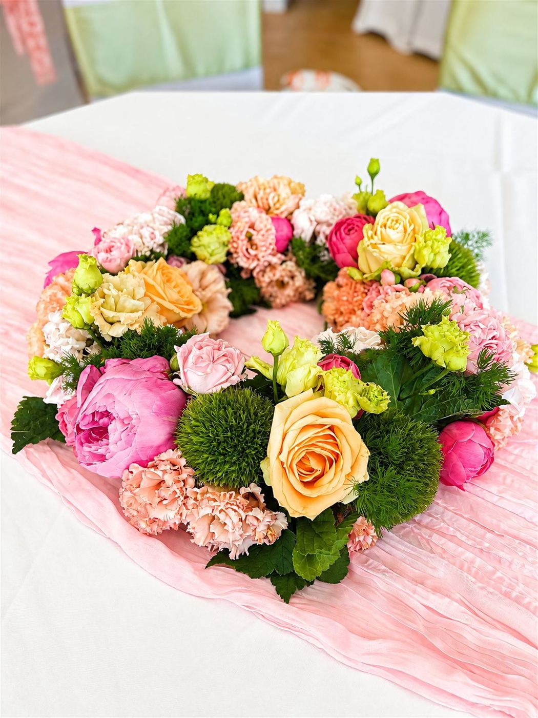 Couronne de centre de table, roses fuchsia, œillets pêche et chrysanthèmes verts