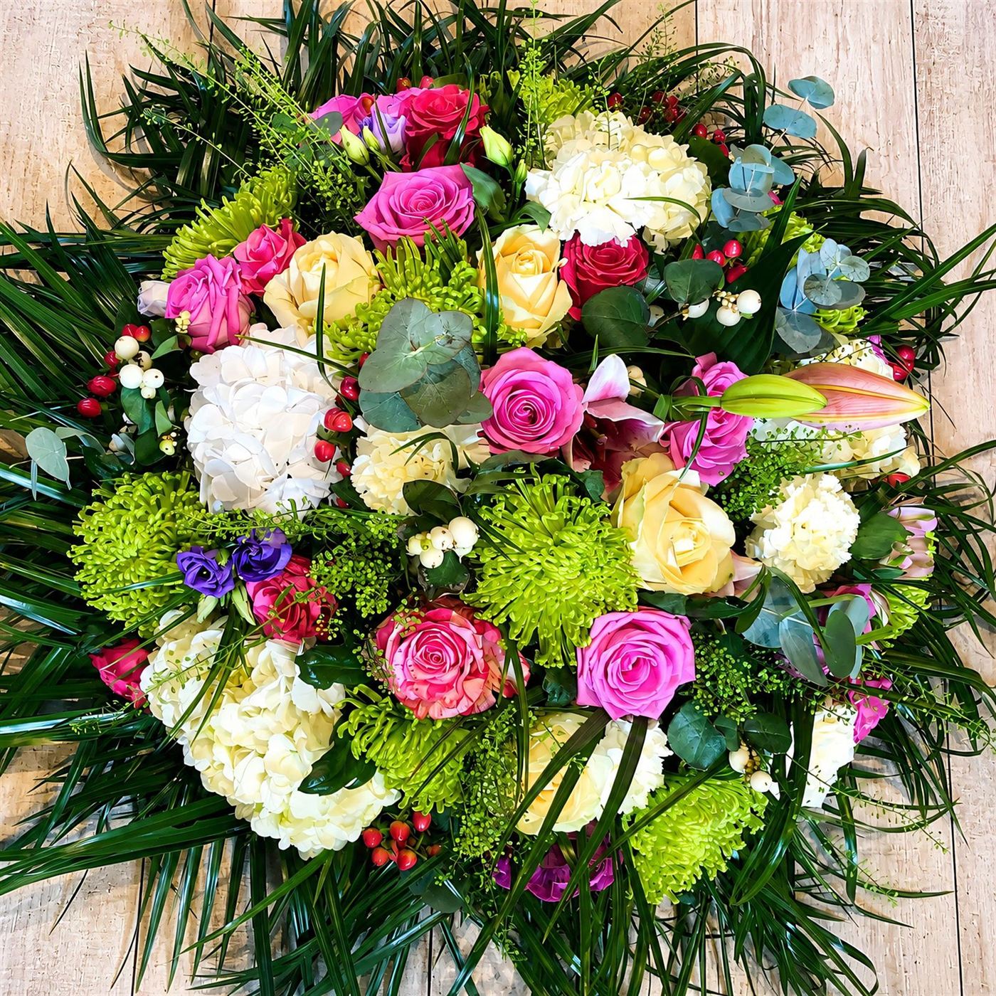 Composition ronde décorative, roses fuchsia, hortensias, chrysanthèmes et lys